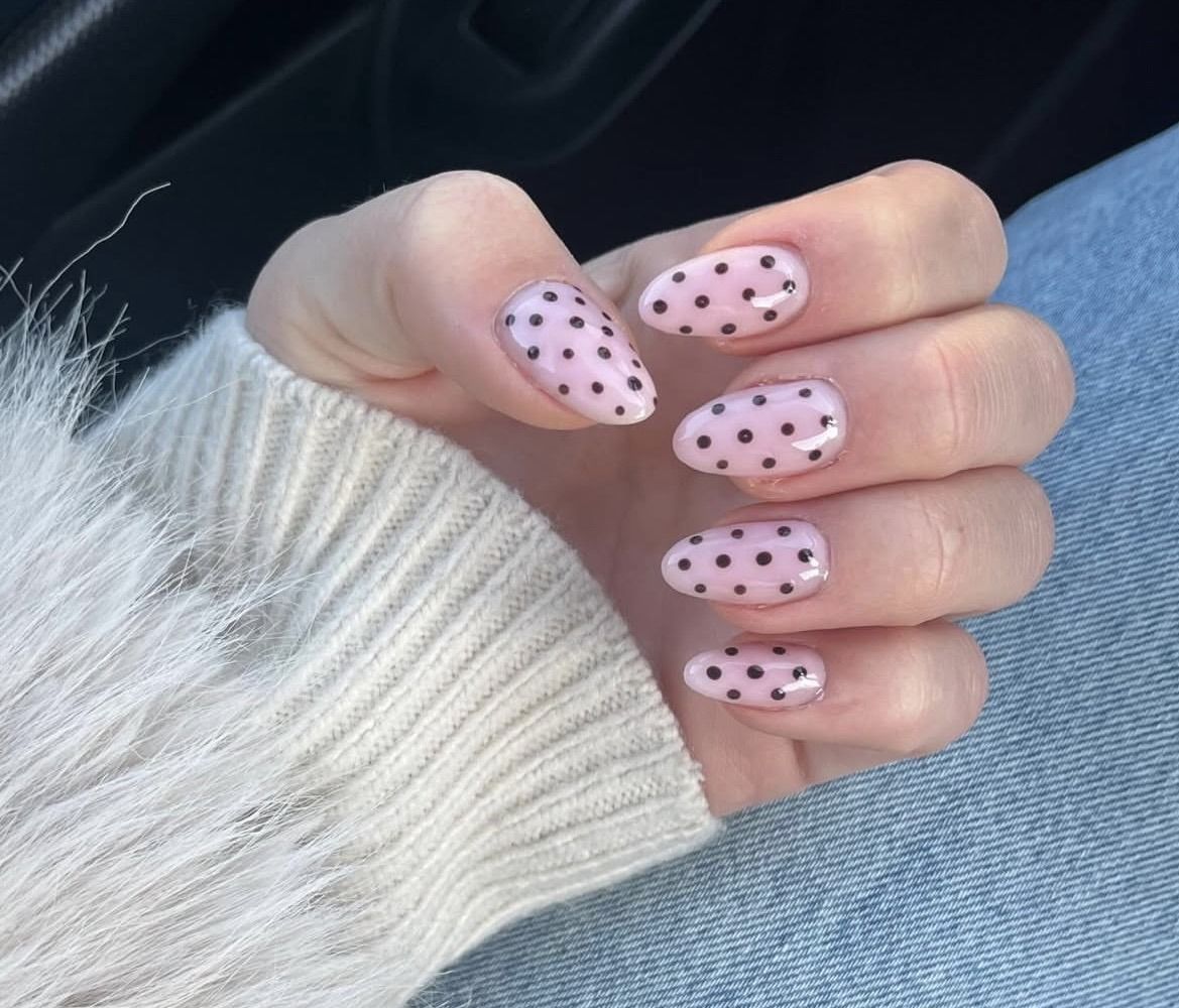 Roze amandelnagels met zwarte stippen